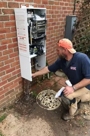 Kevin Tidwell, owner of Crew Plumbing & Drain, working on a tankless water heater